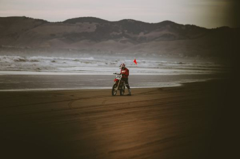 man riding motocross dirt bike near seashore man riding motocross dirt bike near seashore