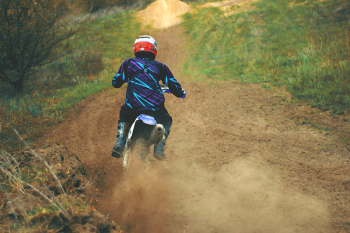 Man Riding Motocross Dirt Bike on Dirt Road Man Riding Motocross Dirt Bike on Dirt Road