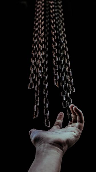 man's hand and chains man's hand and chains