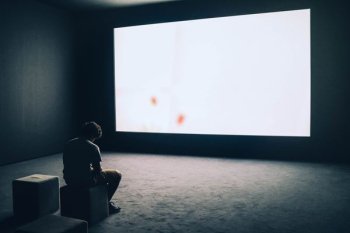 man sit in front projector screen man sit in front projector screen