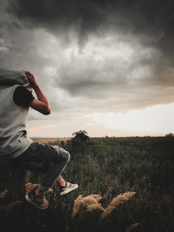Man Sitting at the edge of a Cliff