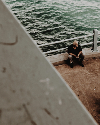Man Sitting Beside Water Man Sitting Beside Water