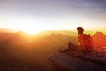 Man Sitting on Edge Facing Sunset Man Sitting on Edge Facing Sunset