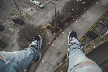 man sitting on rooftop selective focus photography man sitting on rooftop selective focus photography
