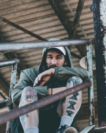 man sitting on stairway wearing green hooded jacket man sitting on stairway wearing green hooded jacket