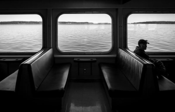 man sitting on watercraft bench grayscale photo man sitting on watercraft bench grayscale photo