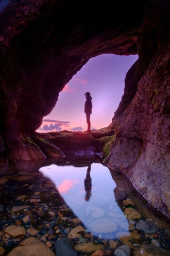 man standing in front of cave man standing in front of cave