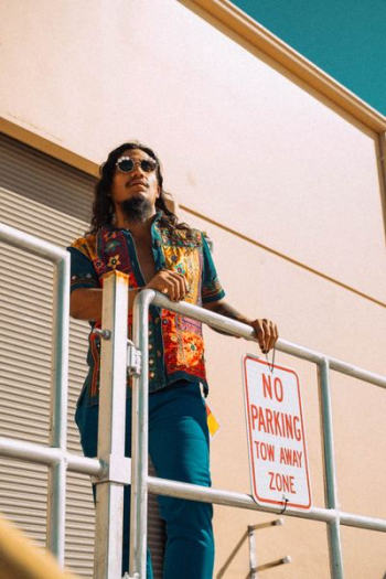 man standing in front of stainless steel fence during daytime