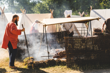 Man Standing in Front of Two Roasted Pigs