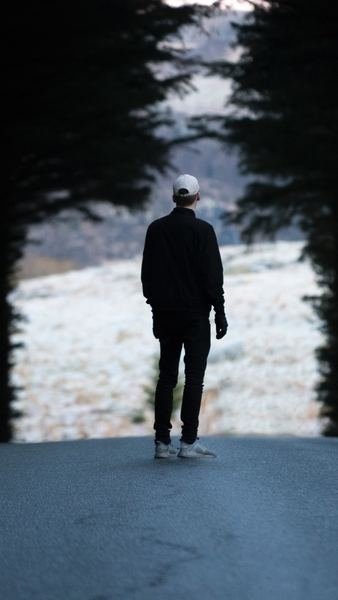 man standing on pathway with trees man standing on pathway with trees