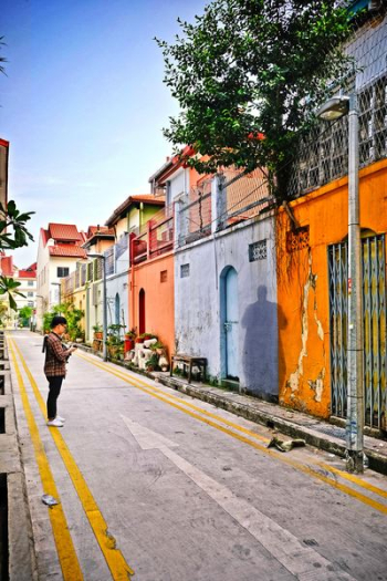 man standing on street facing wall man standing on street facing wall