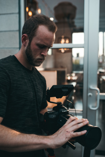 Man Standing While Holding Black Dslr Camera Man Standing While Holding Black Dslr Camera
