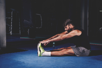 Man stretching in gym Man stretching in gym