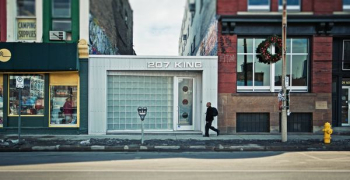 man walking beside 207 King building during daytime man walking beside 207 King building during daytime