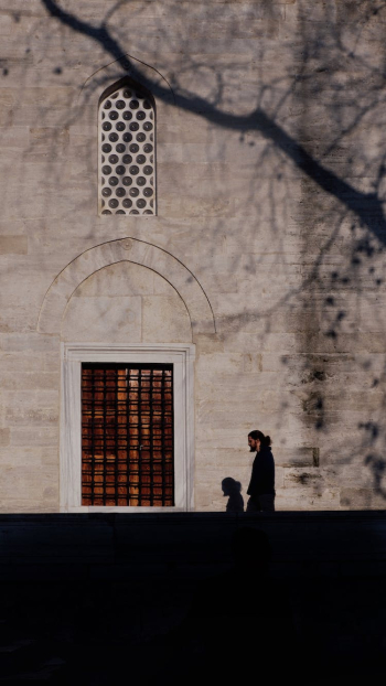 Man Walking by a Building and his Shadow