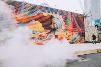 Man Walking On Sidewalk With Wall Painting Man Walking On Sidewalk With Wall Painting