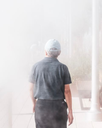 man walking towards smoke-covered building man walking towards smoke-covered building