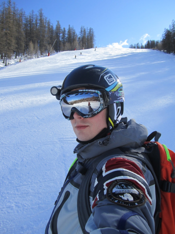 Man Wearing A Jacket And Goggles Standing On Snowy Field Man Wearing A Jacket And Goggles Standing On Snowy Field