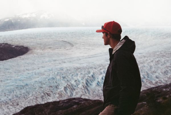 man wearing black hooded jacket on cliff man wearing black hooded jacket on cliff