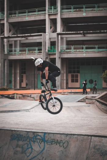 Man Wearing Black Shirt Jumps With Black Bmx Bicycle