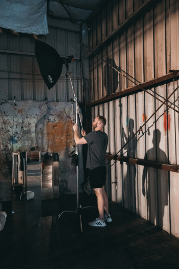 Man Wearing Black T-shirt Standing and Fixing Studio Umbrella Man Wearing Black T-shirt Standing and Fixing Studio Umbrella