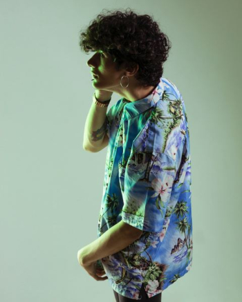 man wearing blue and green floral collared top with white backgrounds