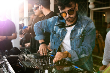Man Wearing Blue Denim Jacket While Using Black Dj Controller