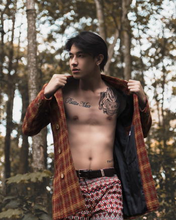 Man Wearing Brown and Yellow Plaid Coat Across Green Trees Man Wearing Brown and Yellow Plaid Coat Across Green Trees