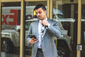 Man Wearing Gray Suit Holding Black Smartphon Man Wearing Gray Suit Holding Black Smartphon