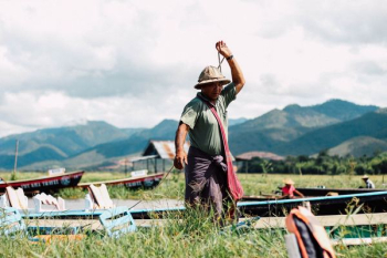 man wearing hat near boat man wearing hat near boat