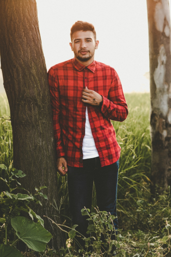 Man Wearing Red Shirt Leaning on Tree Man Wearing Red Shirt Leaning on Tree
