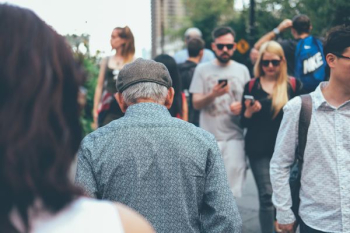 man wearing teal collard shirt walking through couple of people man wearing teal collard shirt walking through couple of people