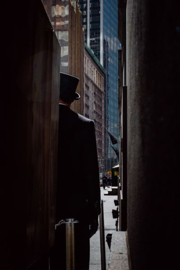 man wearing top hat standing near buildings man wearing top hat standing near buildings