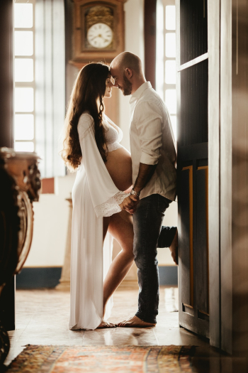 Man Wearing White Dress Shirt Holding Hands With Woman Wearing White Robe