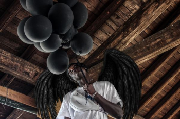 man wearing white shirt holding balloons with wings man wearing white shirt holding balloons with wings