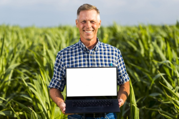 Man with a laptop in a cornfield mock-up Free Photo