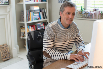 Man working at computer in home office Man working at computer in home office