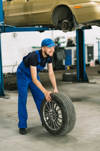 Mechanic rolling wheel to car elevator Mechanic rolling wheel to car elevator
