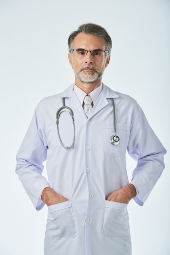 Medium shot of medical specialist standing with arms in pockets looking at camera Free Photo