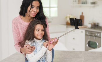 Mom teaching daughter to take selfie Free Photo