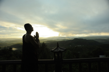 Monk Holding Prayer Beads Across Mountain Monk Holding Prayer Beads Across Mountain