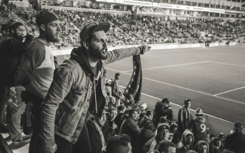 Monochrome Photo of Man Wearing Jacket Pointing Finger at Stadium Monochrome Photo of Man Wearing Jacket Pointing Finger at Stadium