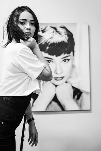 Monochrome Photo of Woman Standing Near Audrey Hepburn Painting Monochrome Photo of Woman Standing Near Audrey Hepburn Painting