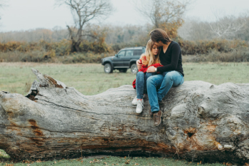 Mother and Daughter Sitting on Tree Log Mother and Daughter Sitting on Tree Log