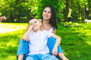 Mother and son sitting on Green Grass Field Mother and son sitting on Green Grass Field
