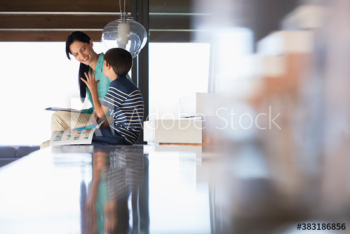Mother and son talking on kitchen counter Mother and son talking on kitchen counter