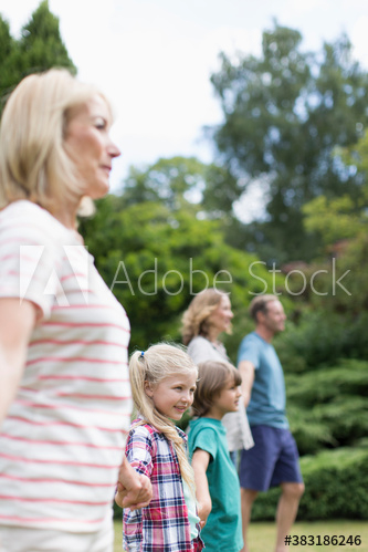 Multi-generation family holding hands in backyard Multi-generation family holding hands in backyard