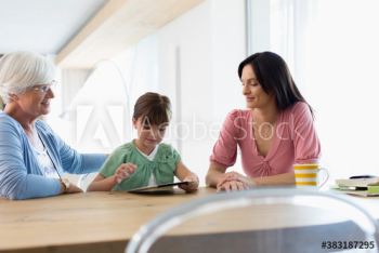 Multi-generation family using digital tablet at dining table Multi-generation family using digital tablet at dining table