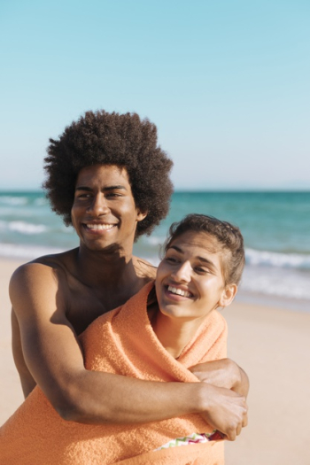 Multiethnic smiling couple on beach hugging Free Photo Multiethnic smiling couple on beach hugging Free Photo