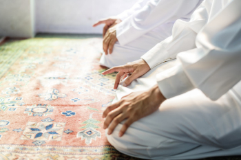 Muslim men praying in Tashahhud posture Muslim men praying in Tashahhud posture